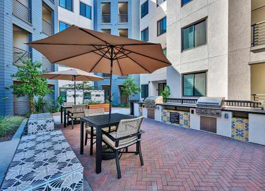 A patio with a table and chairs and an umbrella.
