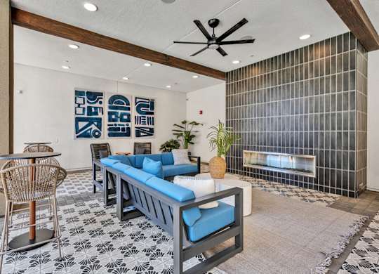 A living room with a blue couch and a black and white tiled floor.