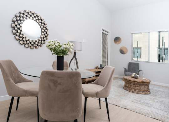 A dining room with a glass table and chairs.