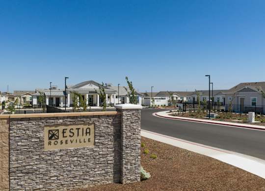 A stone wall with a sign that says Estia Roseville.
