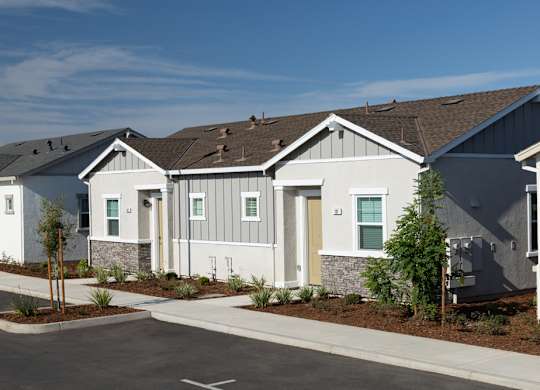 A row of modern houses with a clear blue sky above them.
