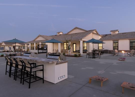 A large building with a patio area in front of it.