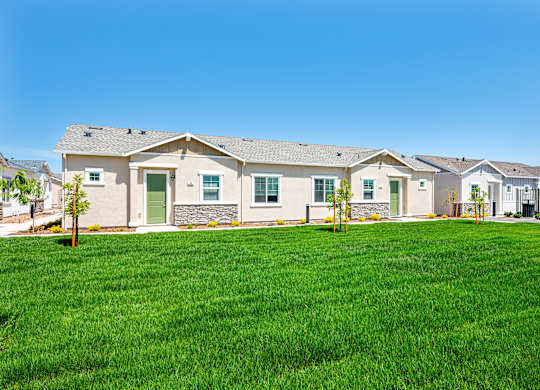 A row of houses with green lawns in front.