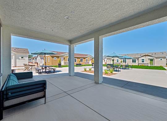 A patio with a bench and a view of a residential area.
