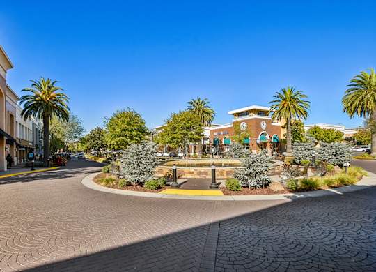 A sunny day in a small town with a roundabout in the center.