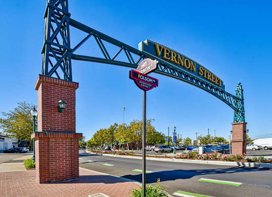A street sign for Vernon Street is displayed on a metal archway.