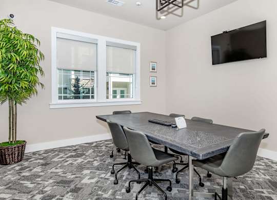 A conference room with a large table and chairs.