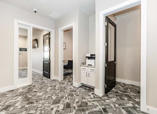A hallway with a patterned floor and white walls.