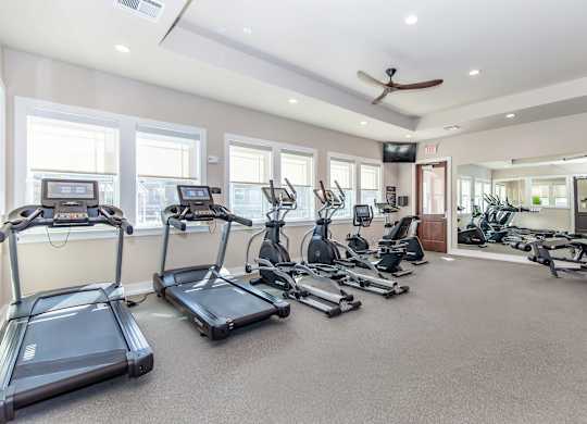 A spacious gym with treadmills, elliptical machines, and other exercise equipment.