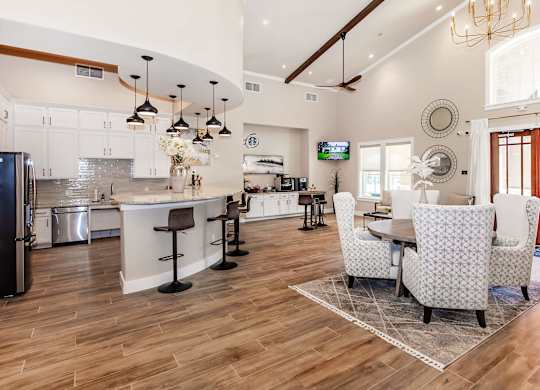 A modern kitchen with a bar area and a dining table set up.