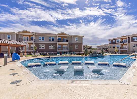 A swimming pool in front of apartment buildings.