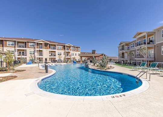 A swimming pool in front of apartment buildings.