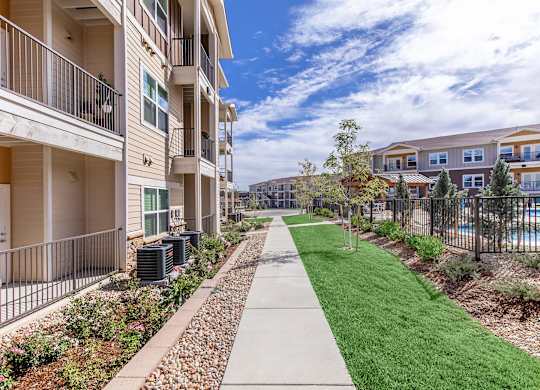 A row of apartment buildings with a walkway in the foreground.