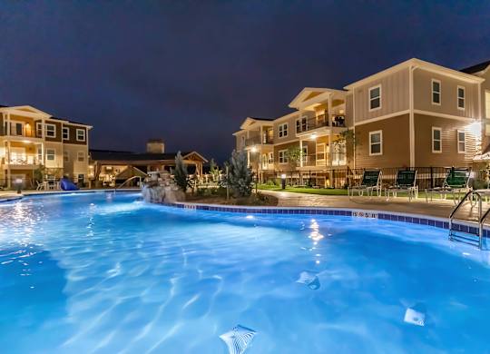 A swimming pool at a resort with a building in the background.