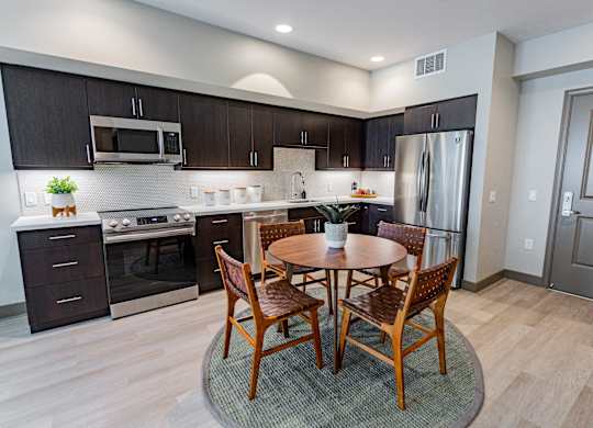 Eat-In Kitchen With Dining Room Table, Black Cabinets, White Countertops, And Stainless-Steel Appliances. at Bayswater Apartments, Burlingame