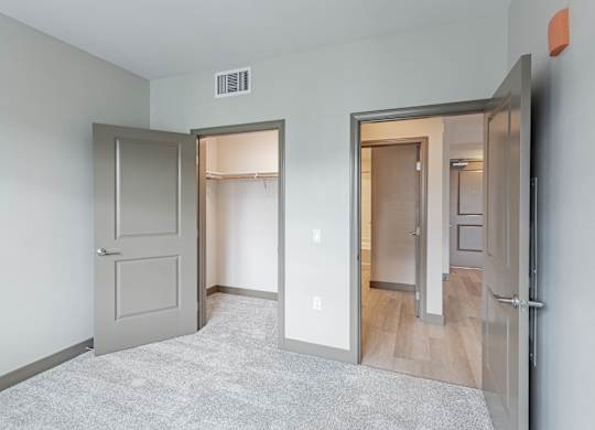 Bedroom with walk in closet and door to living room at Bayswater Apartments, California