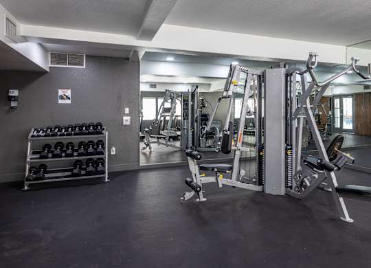 A gym with a variety of equipment including weights and machines at Verandas Apartments, West Covina, CA, 91791