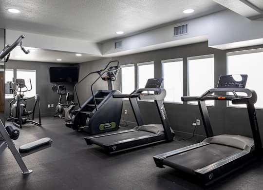 A gym with treadmills, elliptical machines, and other exercise equipment at Verandas Apartments, West Covina, California