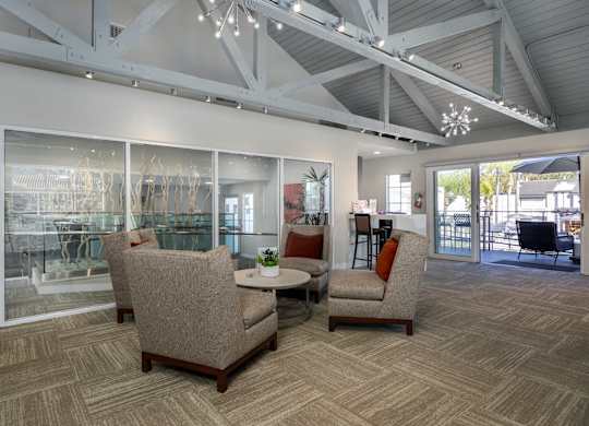 A room with a table and chairs and a glass wall at Verandas Apartments, California
