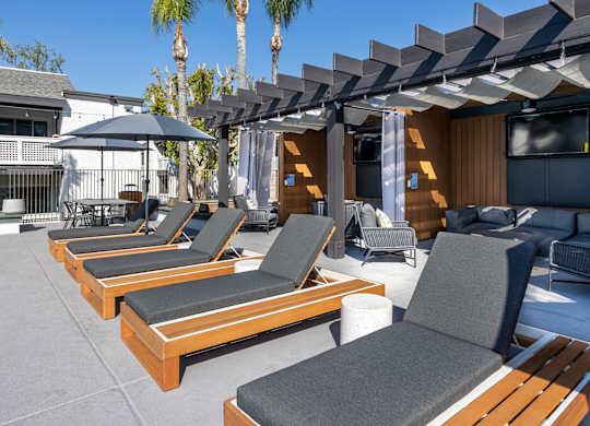 A patio with wooden furniture at Verandas Apartments, West Covina