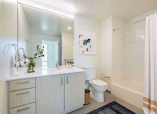 A white bathroom with a toilet, sink, and bathtub.