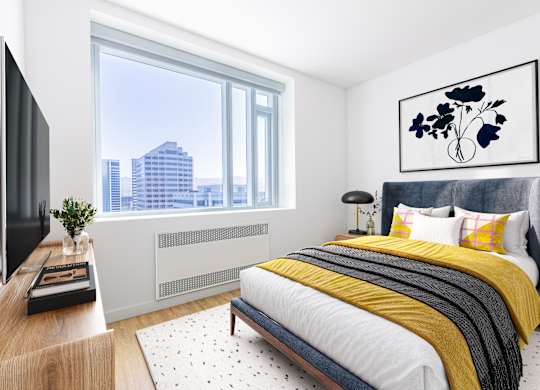 A modern bedroom with a large bed and a city view through the window.