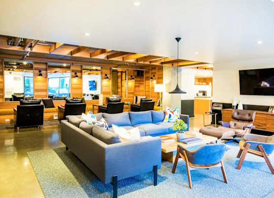 A living room with a grey couch and blue chairs.at The Rise, San Francisco, CA  