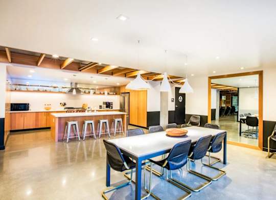 A modern dining room with a long table and blue chairs.at The Rise, San Francisco  
