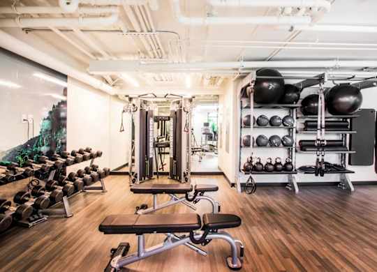 A gym with a variety of equipment including weights and a bench.at The Rise, California, 94103
