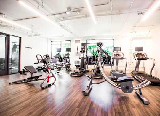 A gym with a variety of equipment including treadmills, stationary bikes, and weight machines.at The Rise, San Francisco, 94103  