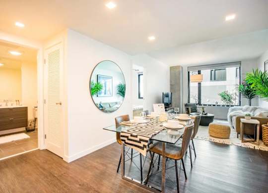 A modern dining room with a glass table and chairs.at The Rise, California  