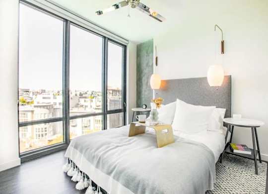 A bedroom with a large bed and a view of the city.at The Rise, San Francisco, CA 94103  