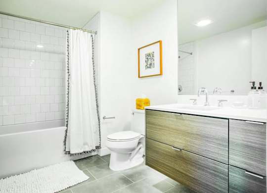 A bathroom with a white tub, toilet, and sink.at The Rise, California, 94103