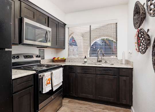 A kitchen with black cabinets and appliances.
