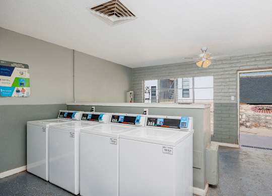 A laundry room with washers and dryers.
