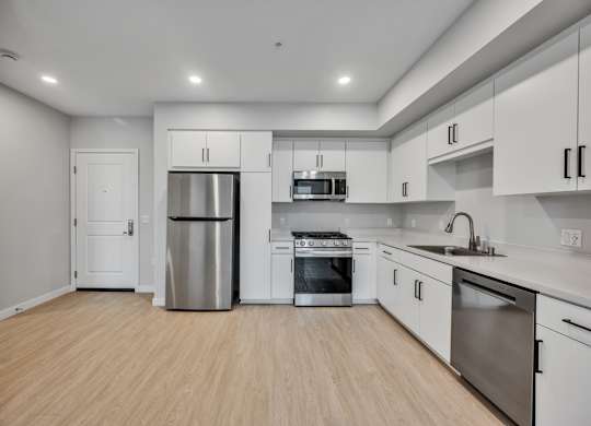 A kitchen with white cabinets and stainless steel appliances.