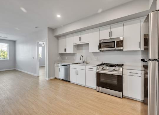 A modern kitchen with white cabinets and stainless steel appliances.
