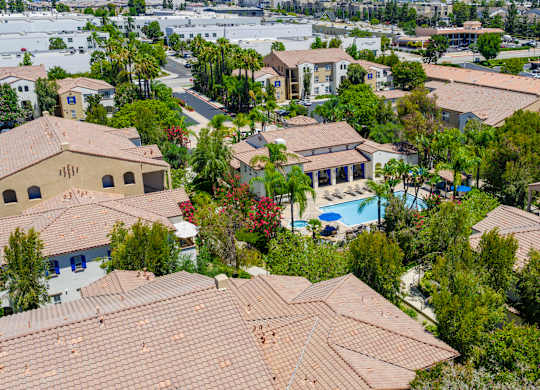A bird's eye view of a residential area with houses and a pool.