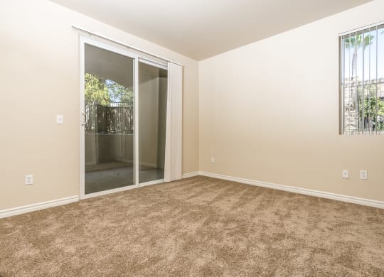 a bedroom with carpet and sliding glass door