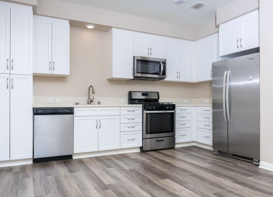 a kitchen with white cabinets and stainless steel appliances