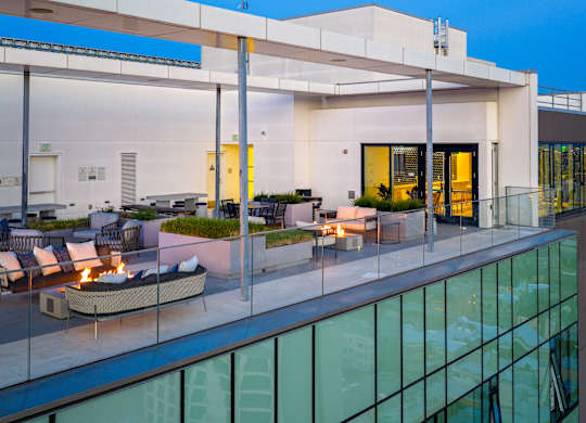 A modern house with a glass balcony and a fire pit.