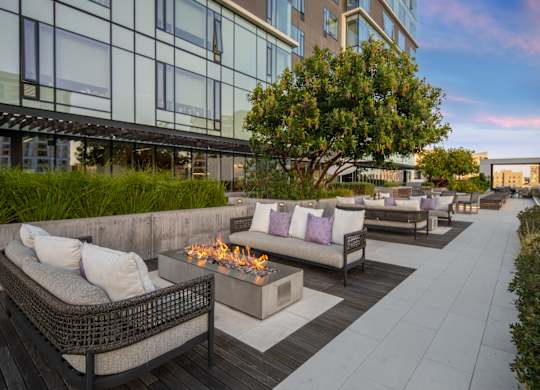 A patio with a fire pit and couches.