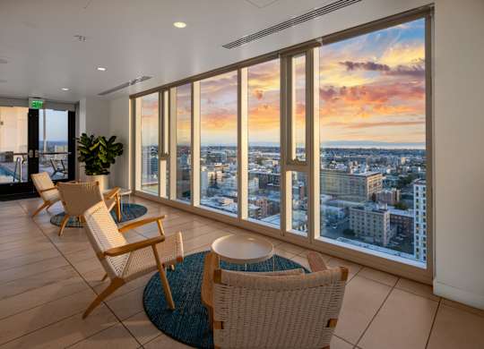 A room with a view of the cityscape at sunset.
