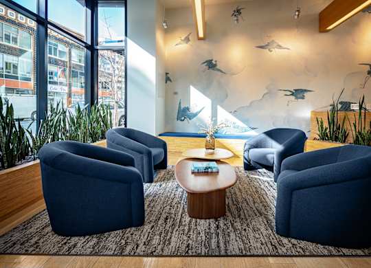 A room with blue chairs and a table with a tray on it.