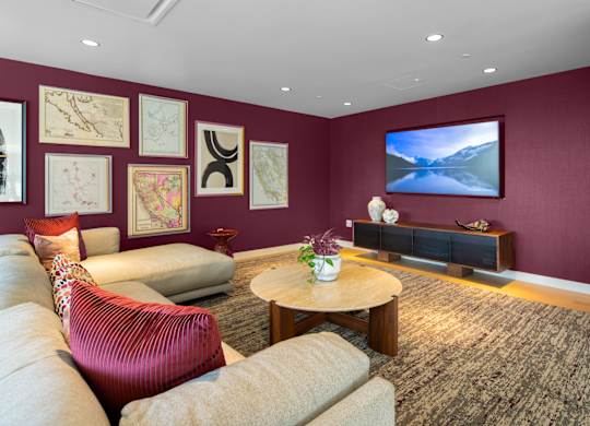 A living room with a red chair and a television.
