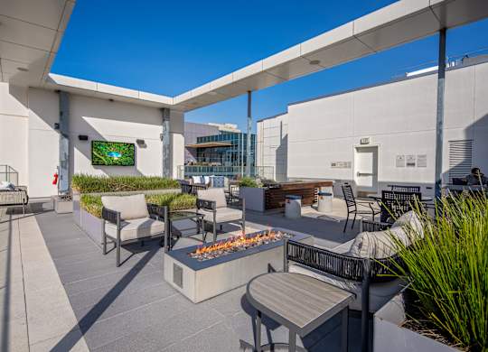 A patio with a fire pit and seating area.