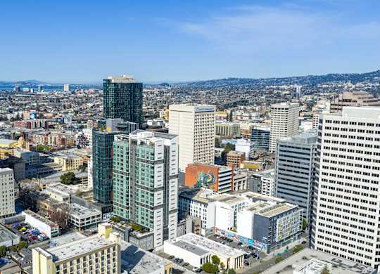 A cityscape with various buildings and a clear sky.