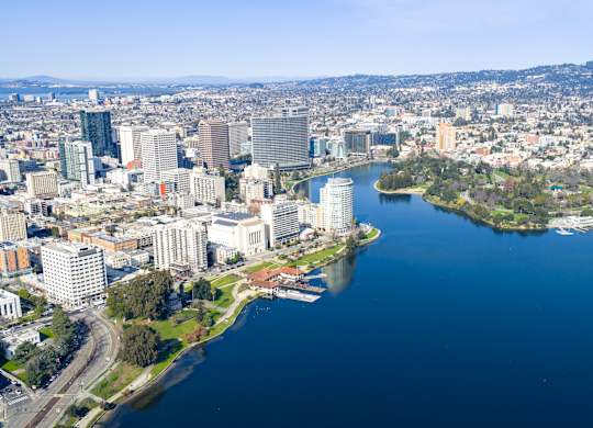 A cityscape with a large body of water in the foreground and a smaller island with buildings.