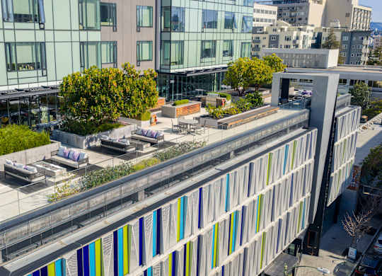 A modern building with a green roof and a glass facade.