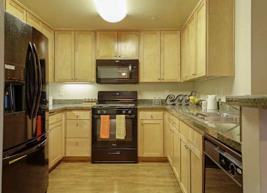 A kitchen with wooden cabinets and a black oven.at 6940 Sepulveda, Van Nuys, 91405  